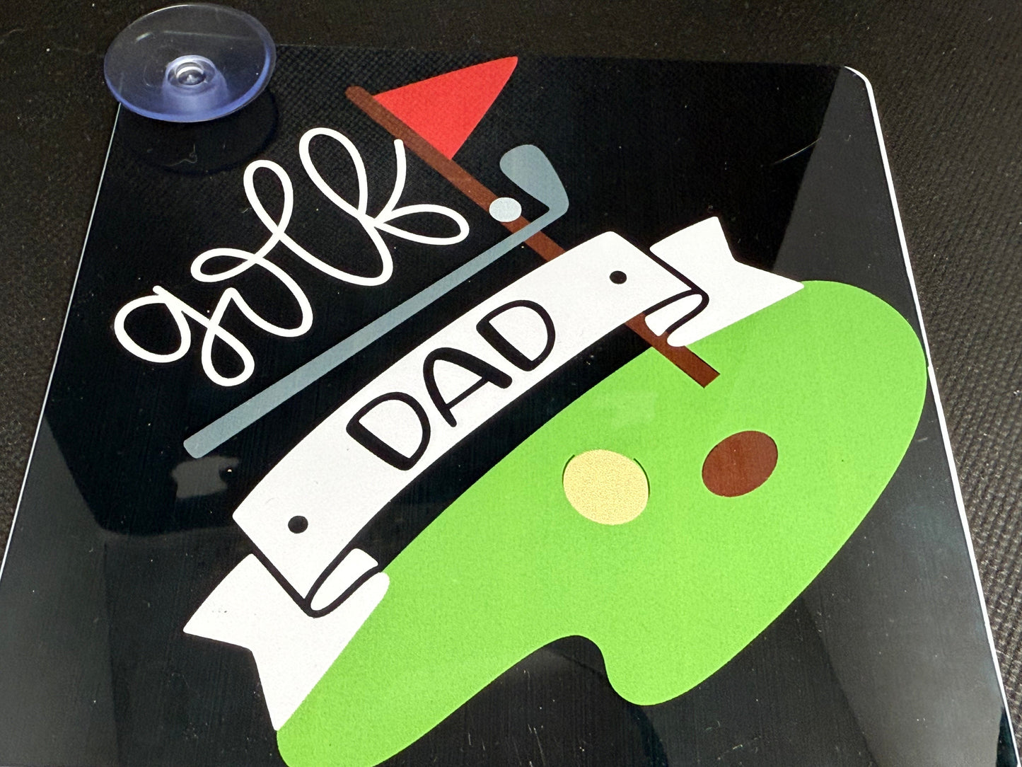 Car sign with a golf theme for 'DAD' text on a black background